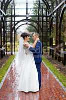 Couple standing in the rain on the wedding day