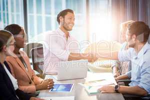 Coworker shaking hands with a colleague during a meeting