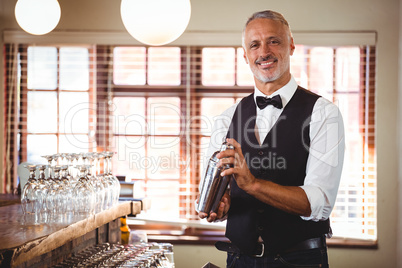 Bartender mixing a cocktail drink in cocktail shaker