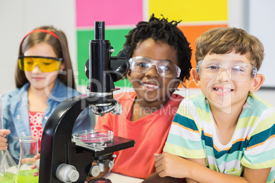 Kids doing experiment on microscope in laboratory