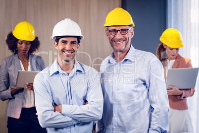 Portrait of two architects standing with arms crossed in office