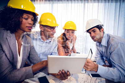 Architects discussing over digital tablet in office