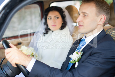 Young couple sitting  inside retro car