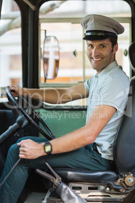 Smiling bus driver driving a bus