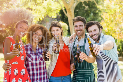 Group of friends showing beer bottle in park