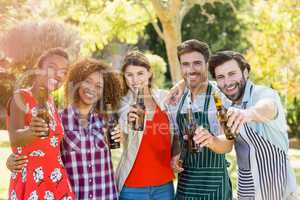 Group of friends showing beer bottle in park