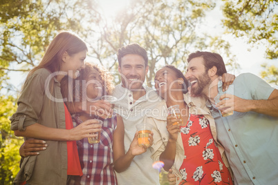 Group of friends holding a glasses of beer in park