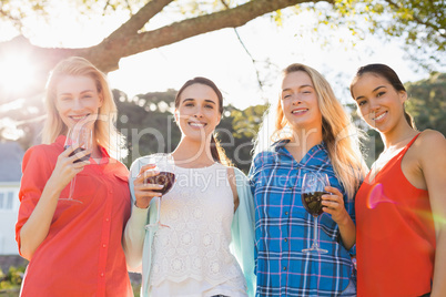 Beautiful women holding a glasses of red wine in park