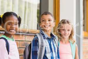 Smiling school kids standing in corridor