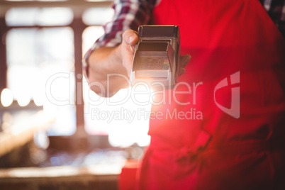 Mid section of waiter showing credit card machine