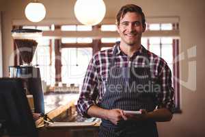 Portrait of bartender standing with notepad