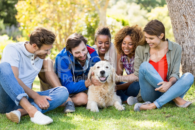 Group of happy friends sitting together with the dog