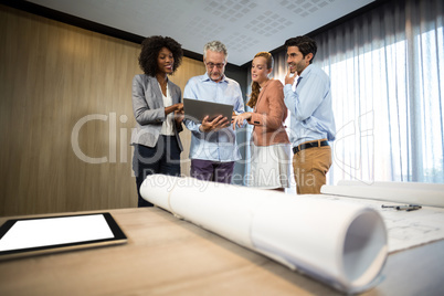 Business people discussing over laptop in office