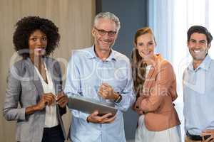 Portrait of smiling business people standing together with lapto