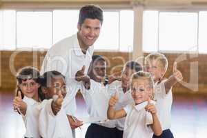 Portrait of sport teacher and students showing thumbs up