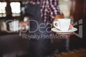 Waiter handing over a coffee