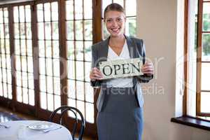 Woman holding a sign with open