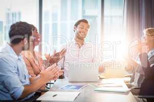 Coworkers applauding a colleague after presentation