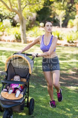 Young woman walking with baby stroller