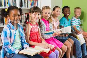 Portrait of kids reading book in library