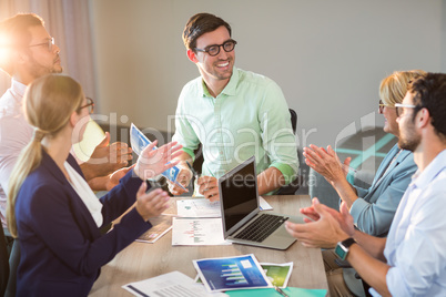 Coworkers applauding a colleague after presentation