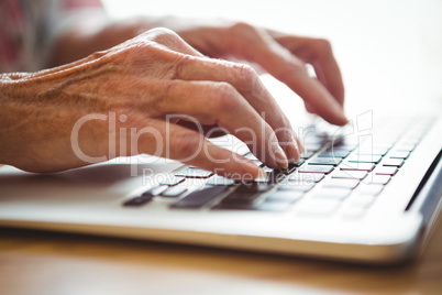 Close-up of hands typing on a laptop keyboard