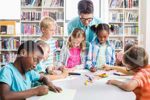Teacher helping kids with their homework in library