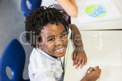 Portrait of schoolboy studying in classroom