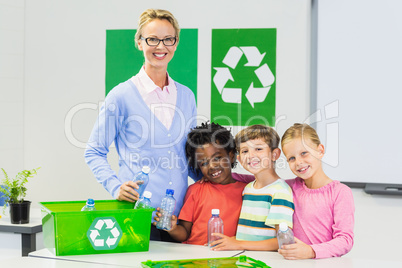 Portrait of teacher and kids standing in classroom