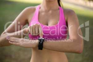 Woman adjusting a time on wristwatch