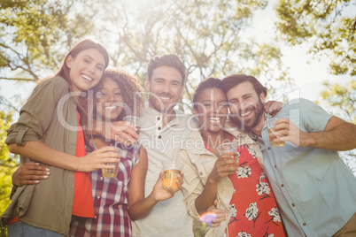Group of friends holding a glasses of beer in park