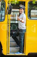 Bus driver standing at the entrance of bus and gesturing