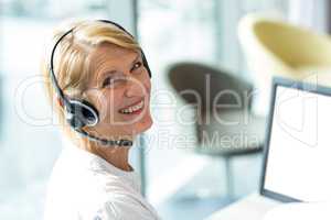 Woman working on computer with headset