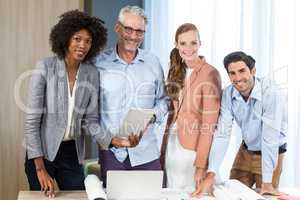 Businesswoman and coworker with blueprint on the desk