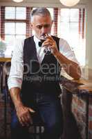 Bartender drinking wine at bar counter