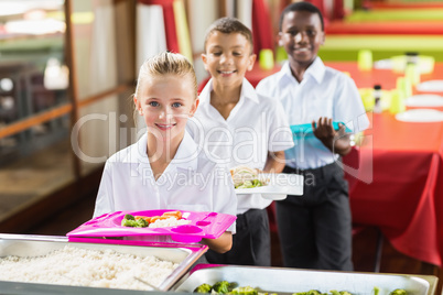 Portrait of school kids having lunch during break time