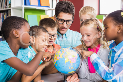 Teacher and kids discussing globe