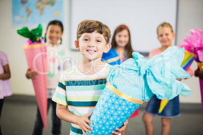 Schoolboy holding gift in classroom