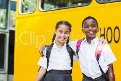 Smiling kids standing in front of school bus