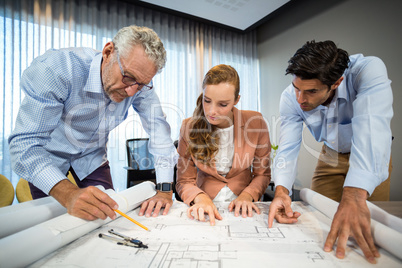 Businesswoman and coworkers discussing blueprint