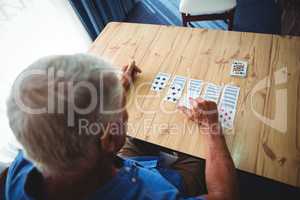 Senior man playing cards on a table