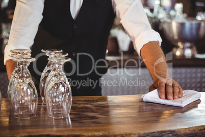 Mid section of bartender cleaning a bar counter