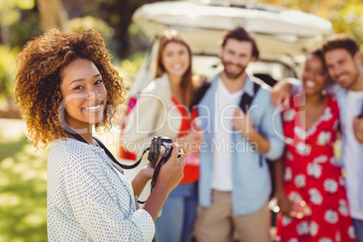 Smiling woman clicking a photo of her friends