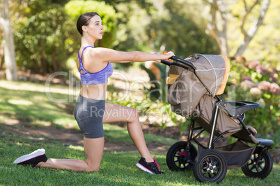 Young woman exercising with baby stroller
