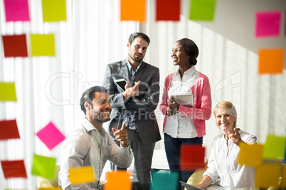 Business people discussing over adhesive notes