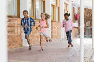 Smiling school kids running in corridor