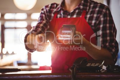 Mid section of waiter showing credit card machine