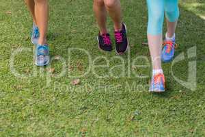 Female athlete feet running on grass
