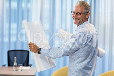 Portrait of man holding blueprint