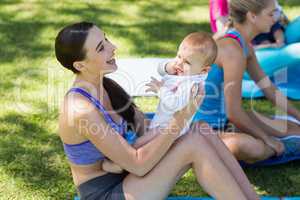 Women holding her baby while exercising
